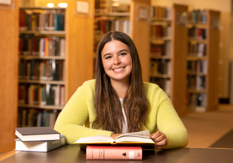 student in front of bookcases