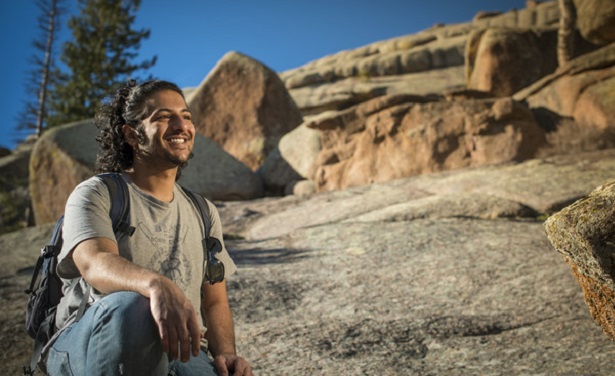 Student outside surrounded by rocks