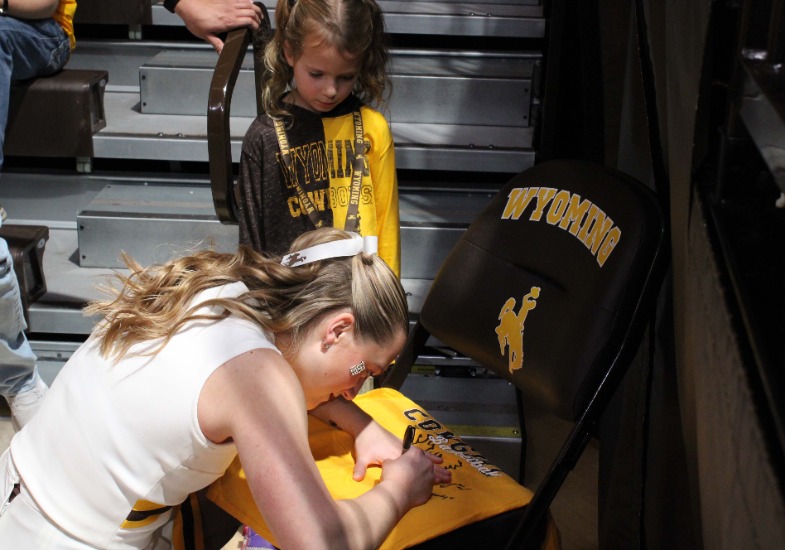Allie autographing a t-shirt for a little fan