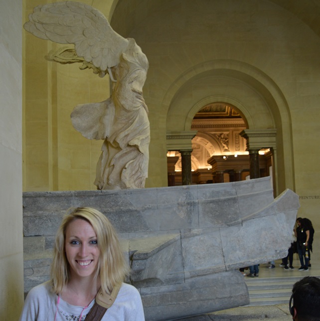 Breezy Taggart standing in front of the Nike of Samothrace in the Louvre