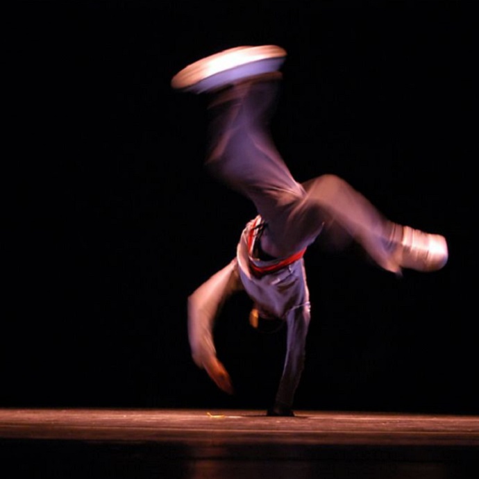 A breakdancer doing a one-handed handstand