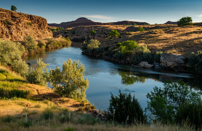 A mountain landscape with a body of water in the foreground.