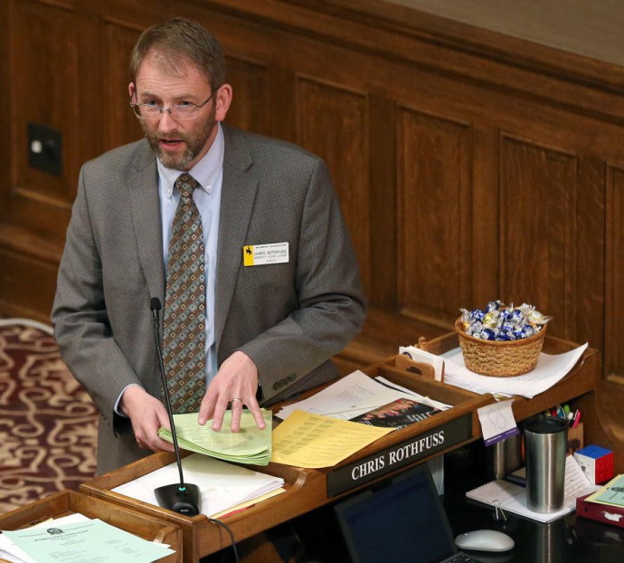 Chris Rothfuss standing in front of a desk