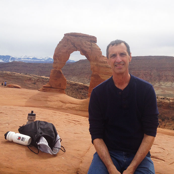 man with stone arch behind him