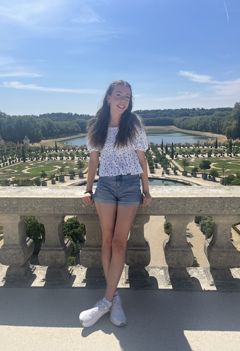 Katie Shields stands on a terrace overlooking the Versailles garden