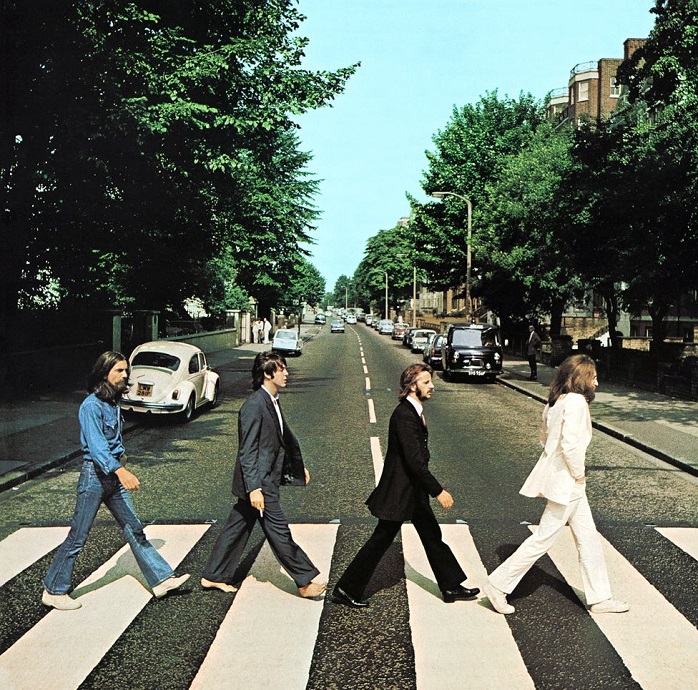 The band members of The Beatles walking on a crosswalk