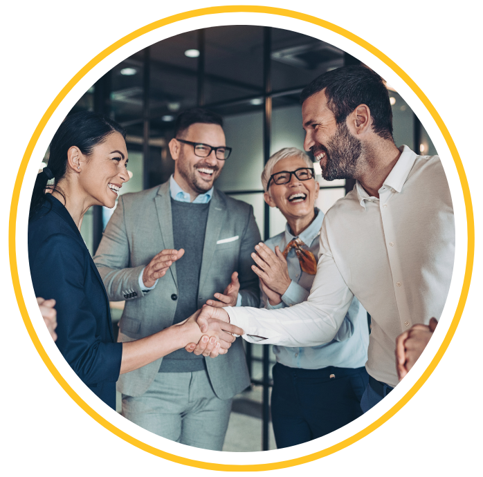 Four business people are standing in an office building having a conversation.