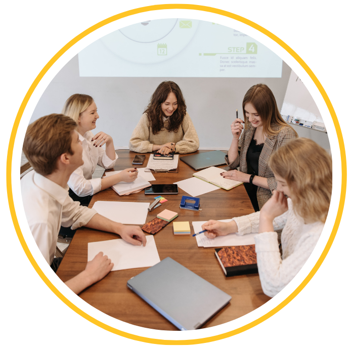 A group of people are working at a table on a project in a conference room.