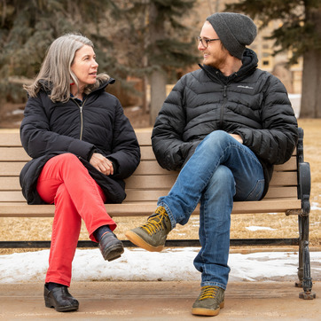 Man and woman having a conversation on a bench on UW campus.
