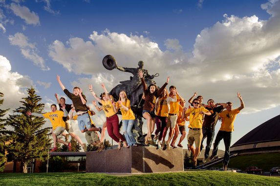 Group of students jumping by the Arena Auditorium