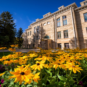 Old Main building with black eyed susan flowers in the foreground