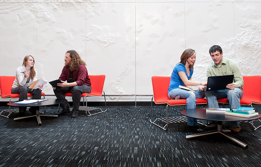 group mingling in a large room with laptops
