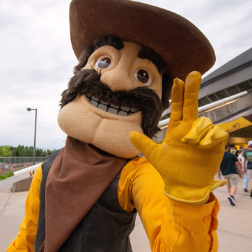 Pistol Pete waving outside Arena Auditorium.