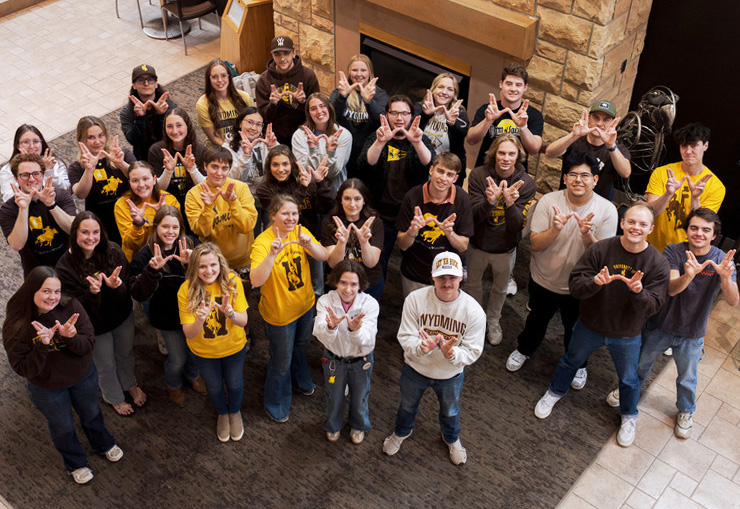 Group of UW students making a W symbol with their hands.