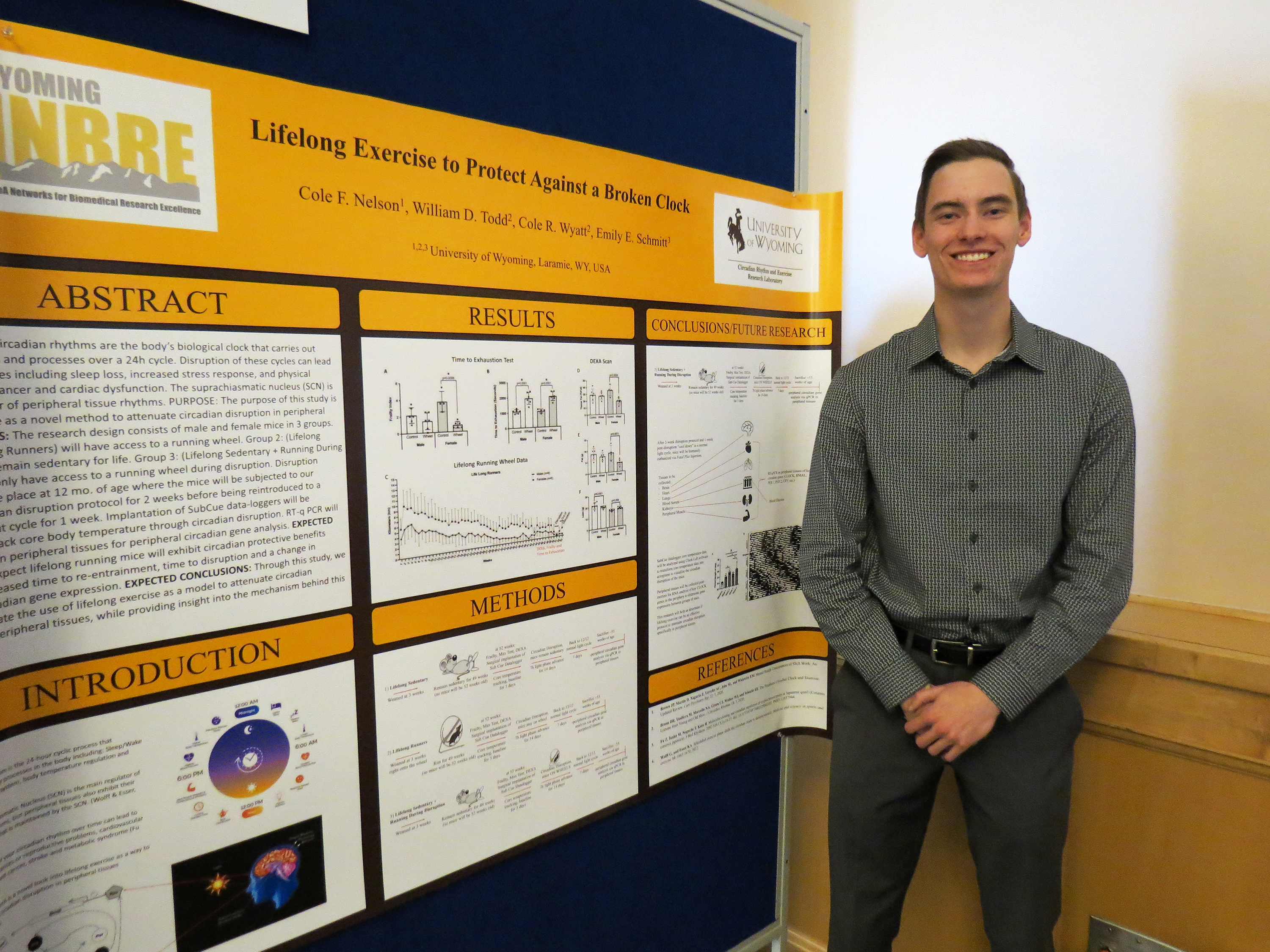 A male student standing in front of a research poster. 