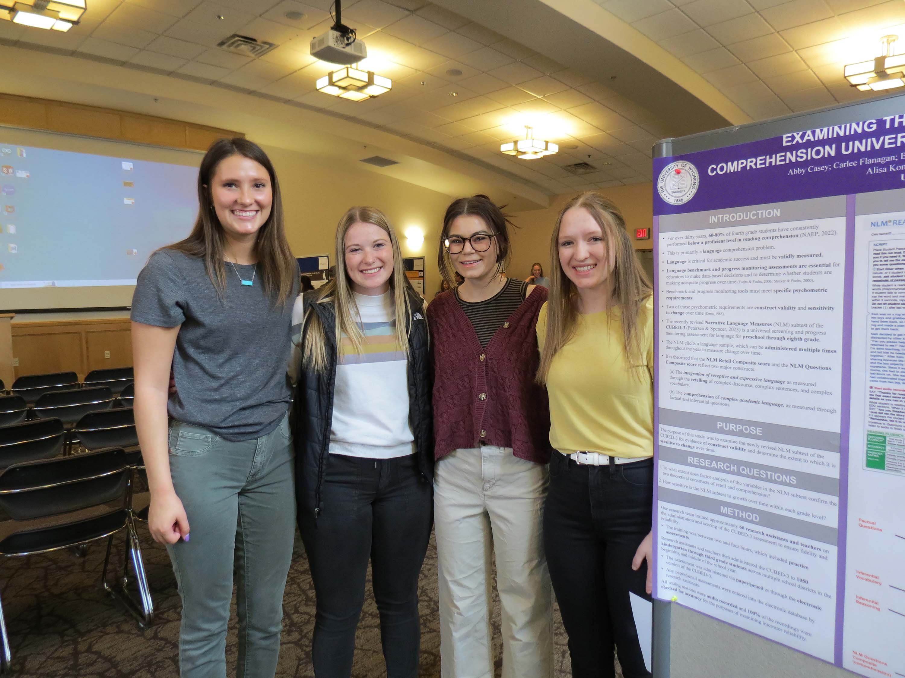 A group of female students standing in front of a research poster.
