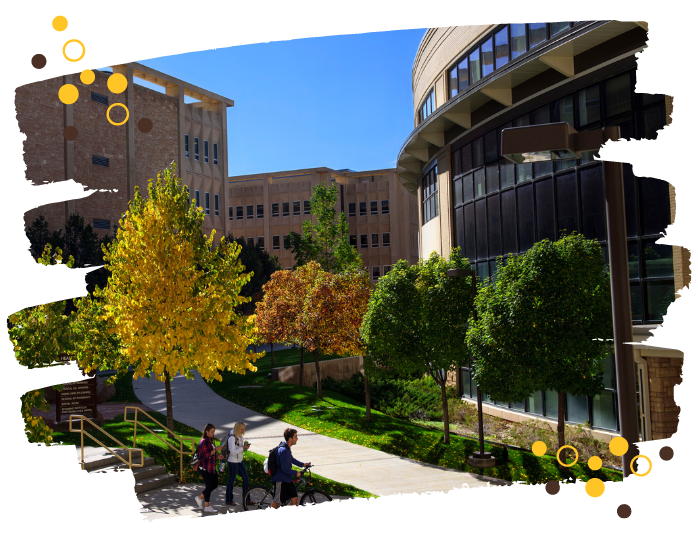 A photo of the UW Health Sciences building with students walking their bikes in front