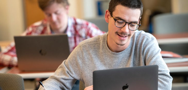 Student in library working at laptop