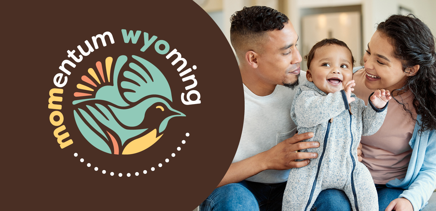 A mom and dad holding a baby as the baby is smiling and laughing.