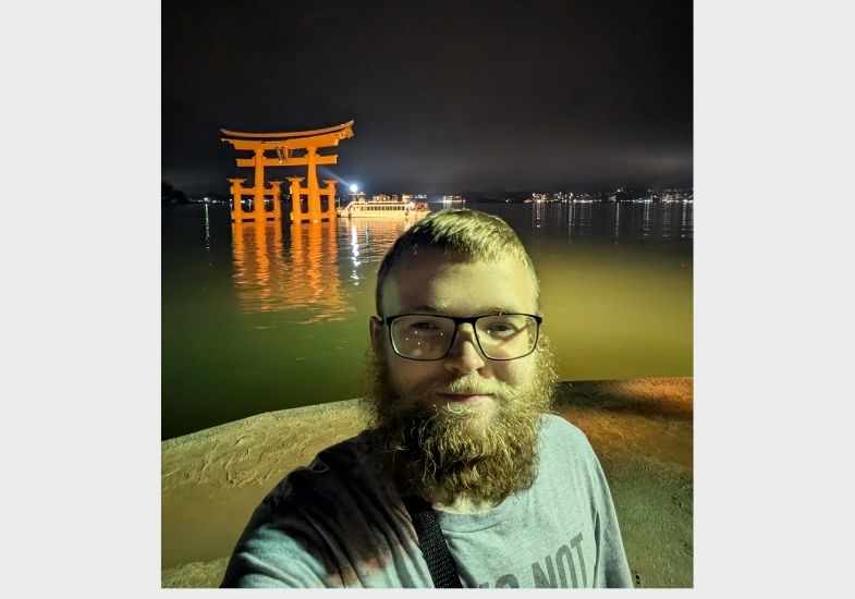 Chauncy in front of a Tori Gate in the water in Japan.