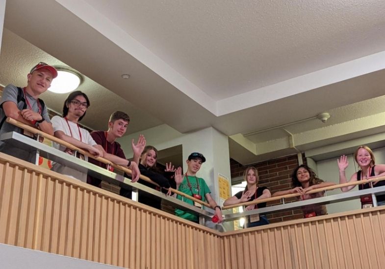 Nolan (corner by pillar) with a large group of HSI students looking down from the overhang on the 6th floor in Downey.