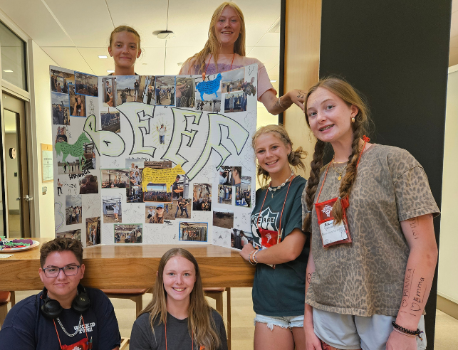 Students beside their class poster for the class Animal Ag.
