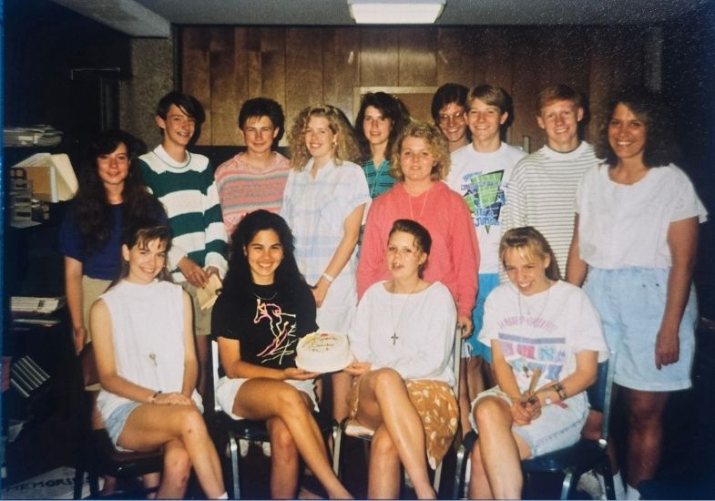 Group of students holding a gathered around a birthday gorup.