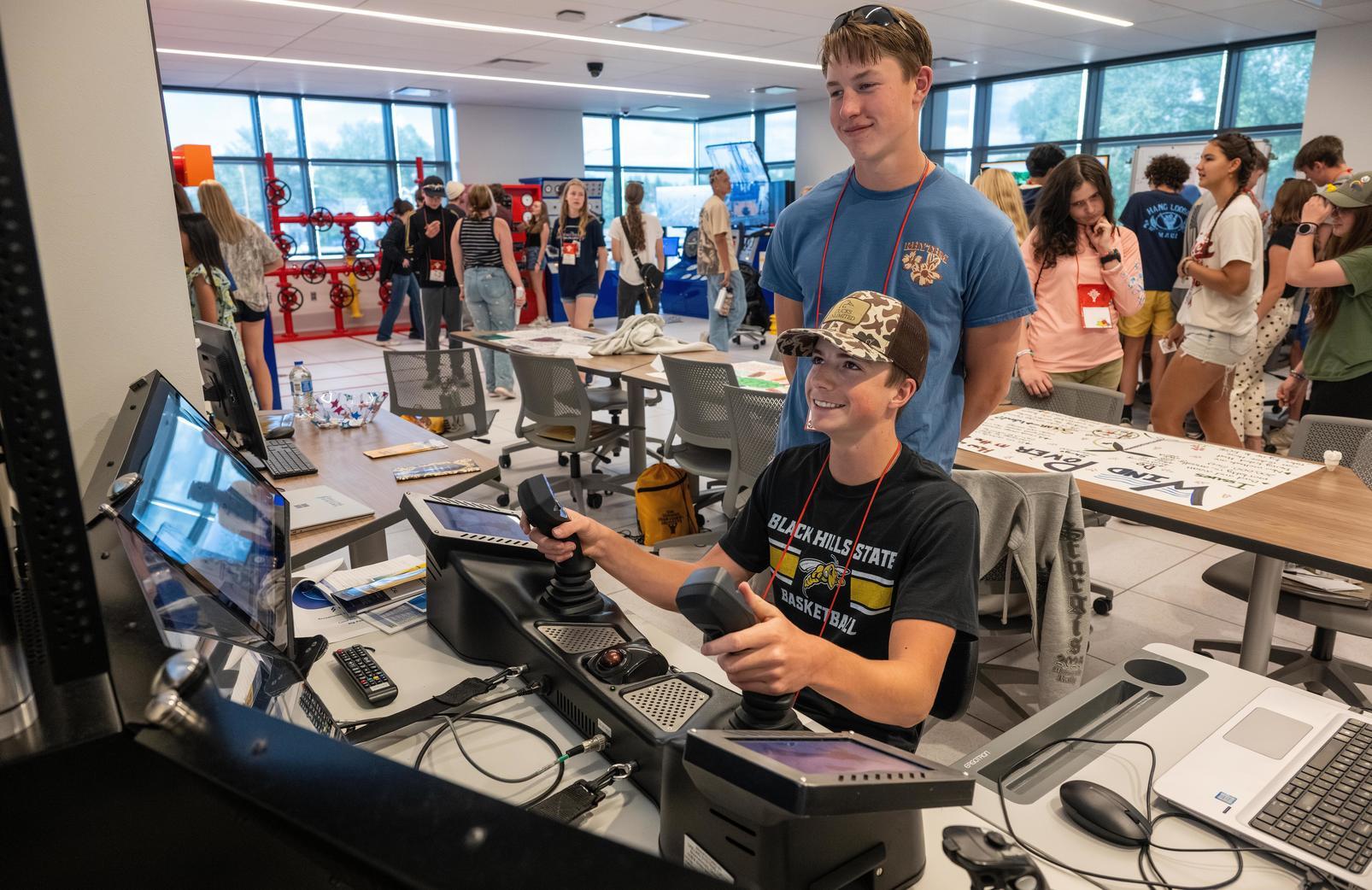 Two HSI male students using an energy lab simulator.