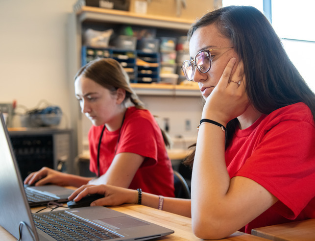 Two female students working on computers in a computer lab.