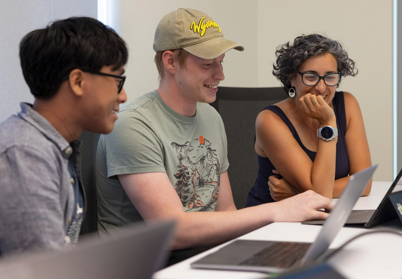 photo of students collaboration around a laptop computer