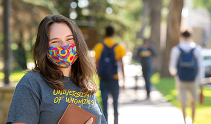 Woman in mask standing on sidewalk