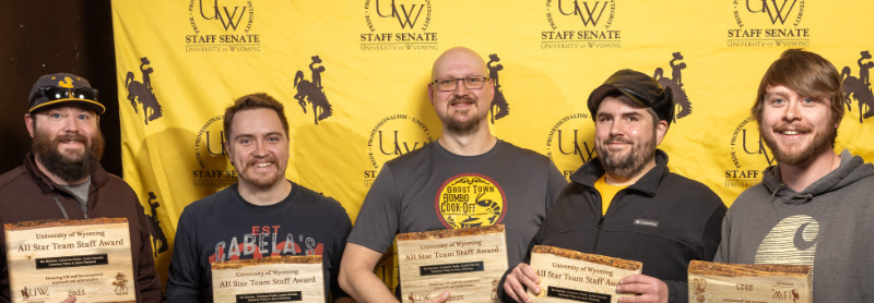 photograph of five smiling CTS team members holding their awards