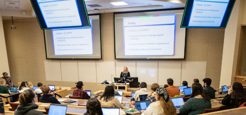 photo of a classroom auditorium with students and a professor