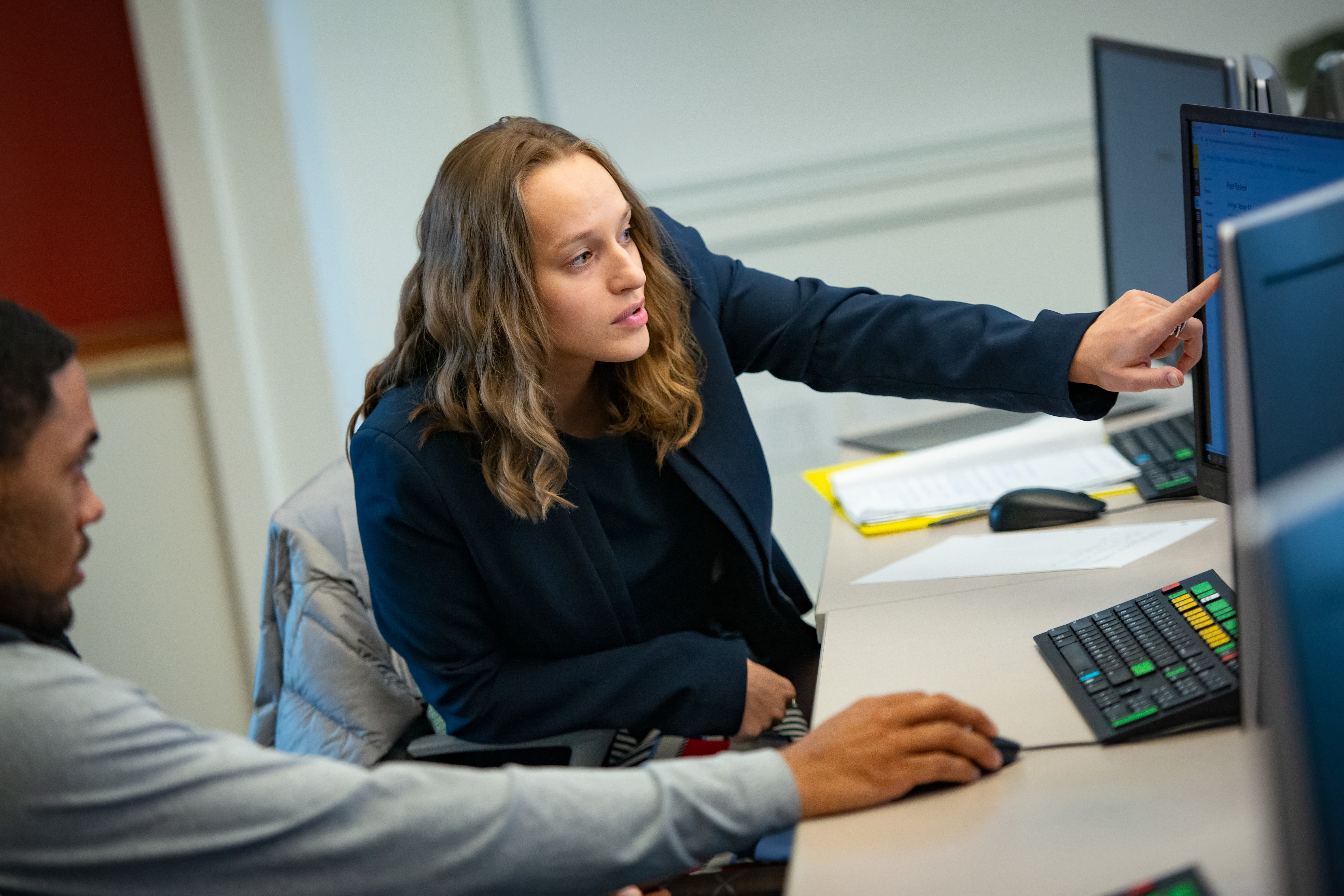 Business student pointing at a computer