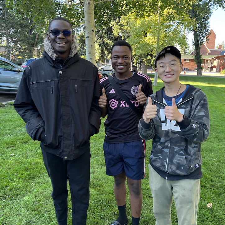 three students smiling in a park