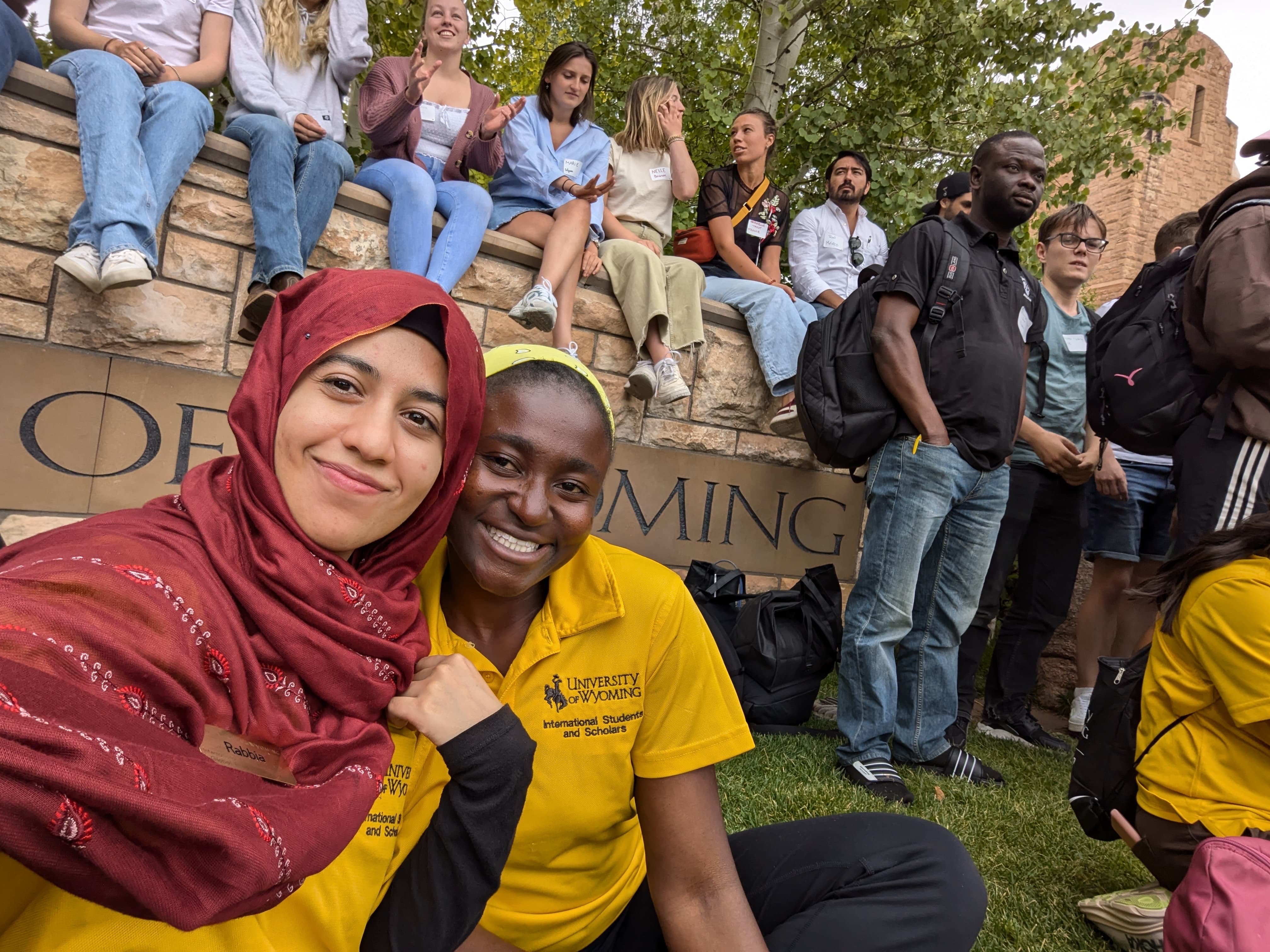 international students smile in front of UW sign