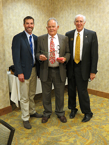 Three men at an awards ceremony. 