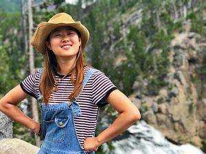 A woman wearing a cowboy hat and demin overalls.