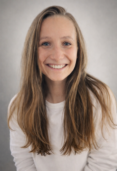 Hillary Smith wearing a white long-sleaved shirt, she has long brown and blonde hair.