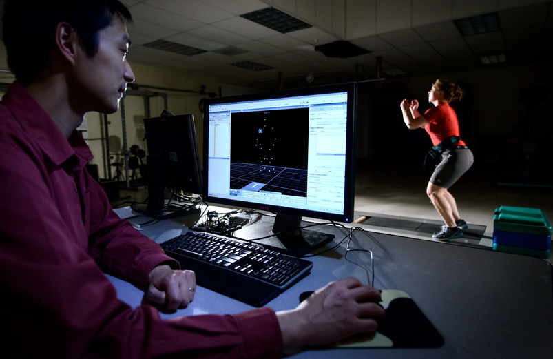 A researcher using a computer to record the motion of a person in the background.