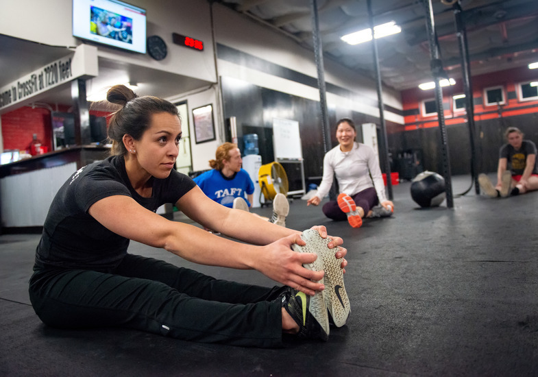 A group of people stretching in a gym.