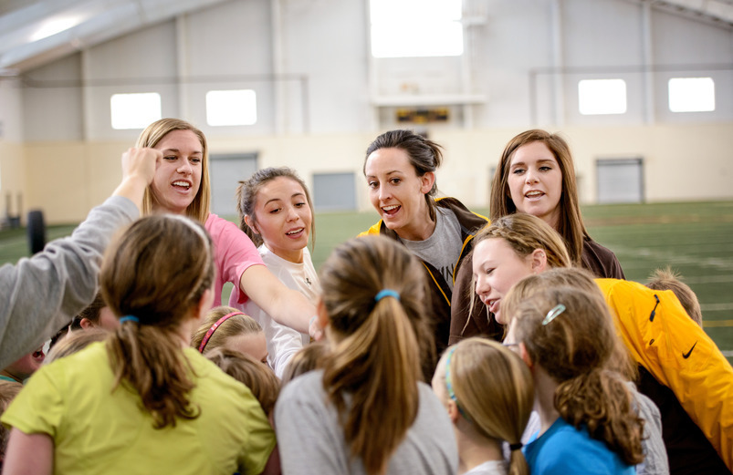 A group of people putting their hands together in a team.