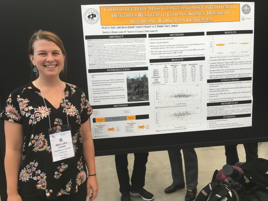 A student standing in front of a research poster presentation.