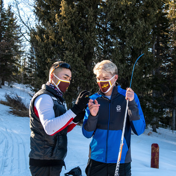 Two people with ski gear looking at a phone.