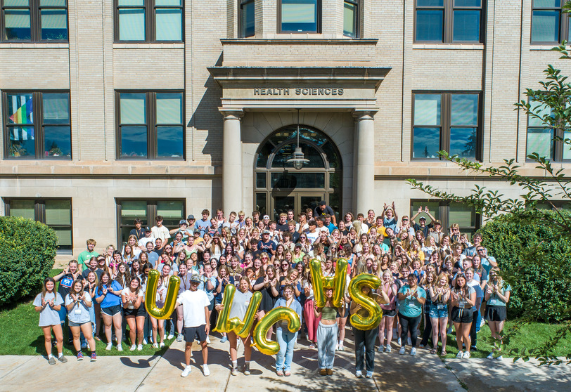 A large group of student in front of the Health Sciences building.