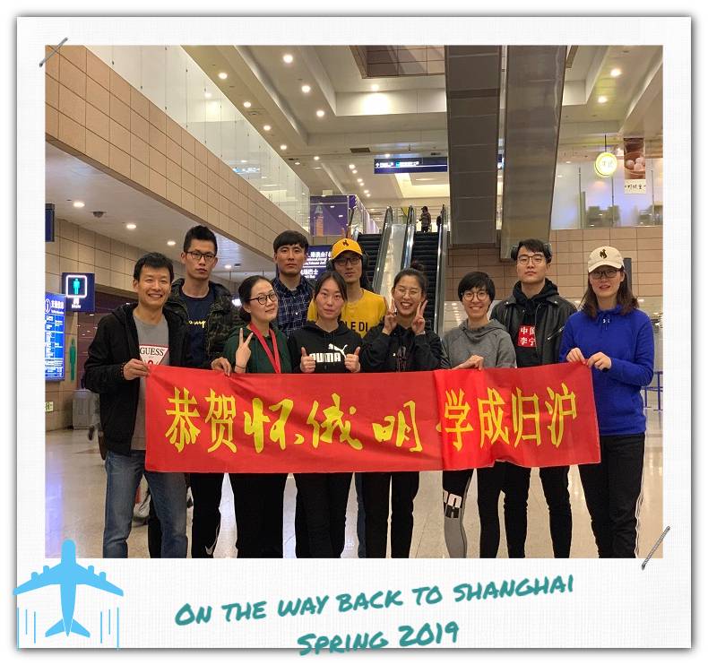 A small group of people holding up a red banner with Chinese writing on it.