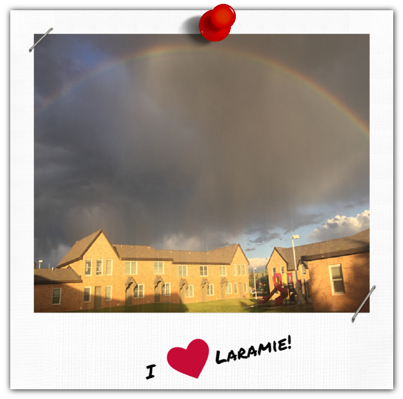 A rainstorm and rainbow over a building.