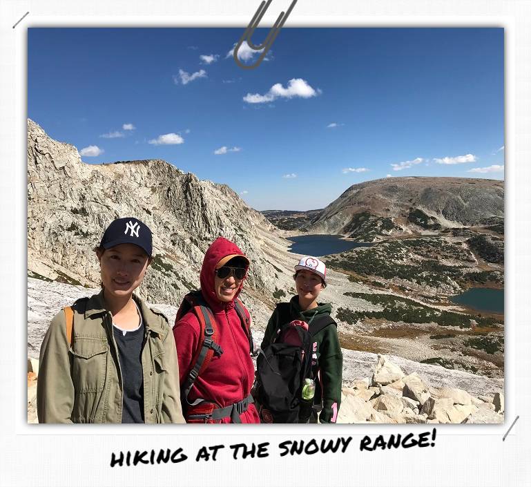 Three people standing in a mountain valley.