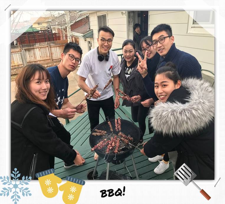 People standing around a BBQ grill holding meat skewers over it.