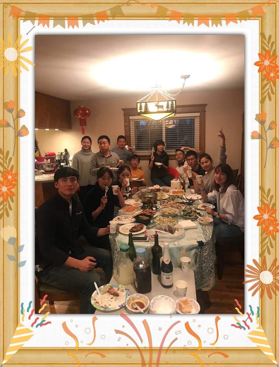 People sitting at a large table covered in dishes full of food.